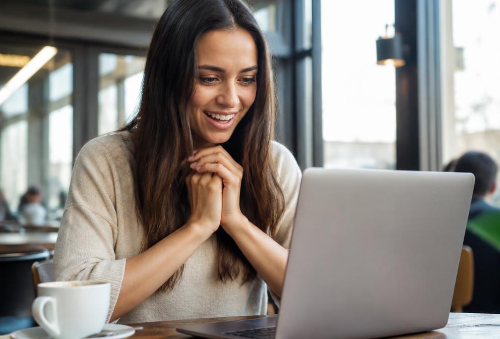 Junge Frau findet erleichtert die gesuchte Information am Laptop